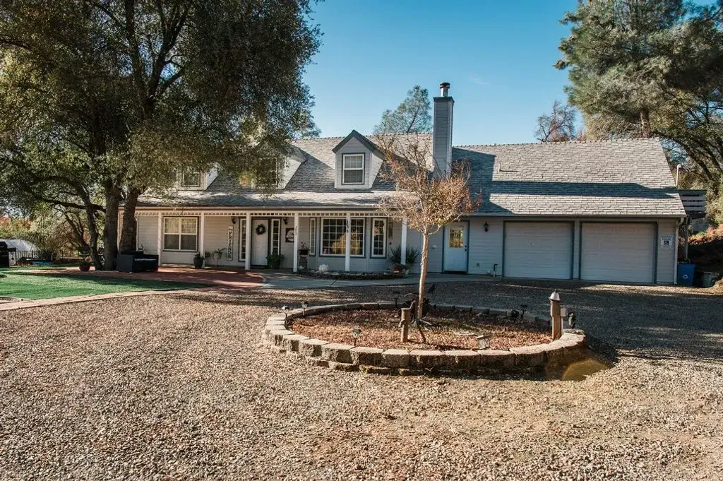A white house with red brick driveway and front porch.